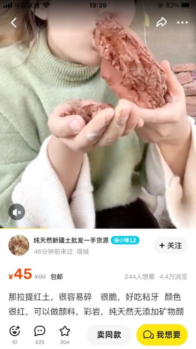 图片展示了一位身穿绿色高领毛衣的女子正在手持并食用大量红色土壤状物体。下方是商品销售界面，显示这是来自新疆塔城的"那拉提红土"，售价45元包邮，宣称"很容易碎、很脆，好吃粘牙"，还可做颜料和彩岩。画面令人惊讶，将土壤作为可食用商品销售的场景十分罕见。