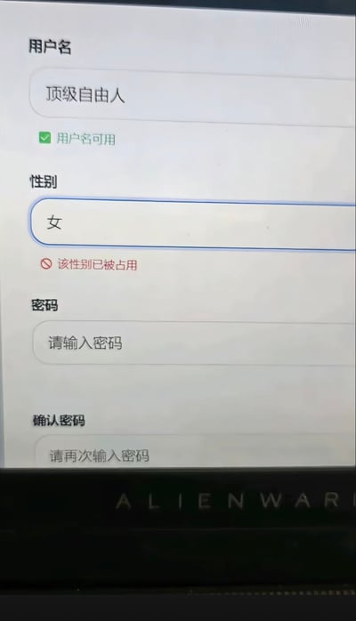 这是一张翻拍的电脑屏幕截图，展示了经过恶搞修改的账号注册页面：用户名输入框填写了“顶级自由人”，下方显示绿色对勾提示用户名可用；性别选择“女”后，下方出现不符合常规逻辑的红色禁止标识，提示“该性别已被占用”，页面下方还有未填写的密码、确认密码输入框，屏幕底端能看到外星人（ALIENWARE）品牌的电脑标识，整体通过违背常识的系统提示制造荒诞的搞笑效果。