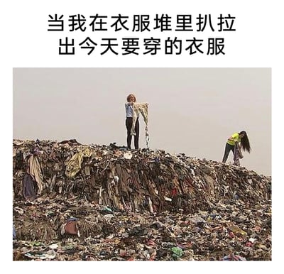 这是一张图文结合的搞笑梗图，顶部配有文字“当我在衣服堆里扒拉出今天要穿的衣服”，下方是一张实拍照片，呈现了两个人在一座堆积如山的旧衣物堆中活动的场景：一人站在衣物堆顶部，双手举着一条裤子查看，另一人在堆体右侧弯腰翻找衣物。图片用夸张的方式，将人们日常杂乱的衣柜放大成垃圾场般的衣物山，调侃很多人明明拥有大量衣物，却找不到合适穿搭的日常窘境，精准贴合当代年轻人的生活状态，充满幽默共鸣感。