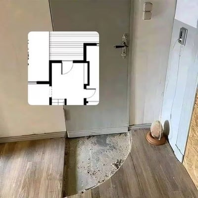 图片左侧嵌入了一张建筑平面图，图中显示一个带有拐角的门廊设计；右侧为实际施工场景——一扇灰色房门被安装在墙角，门框底部被斜着切掉一角，与地面形成一个不规则的三角形缺口，旁边散落着水泥碎屑。整个画面通过平面图与现实施工的对比，讽刺了施工团队机械照搬图纸、缺乏实际考量导致的荒诞结果，充满黑色幽默。