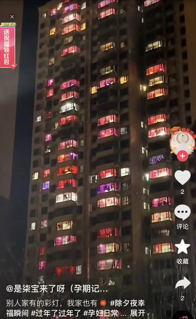 这是一张高层住宅楼夜景照片，楼内许多住户的阳台或窗户都被映照成红色和粉色，整体效果类似于挂满了“彩灯”，十分吸引眼球。实际这些光亮大多是晾晒的红床单、孕妇用品等，和春节氛围巧妙结合。图片配文以自嘲幽默方式对比“别人家的彩灯”和自家的床品彩灯，传达出普通家庭节日中的生活乐趣和自嘲态度，具有生活化梗图的强烈特色。有一定生活现象的双关和幽默隐喻，但没有明显谐音梗和不当暗示。