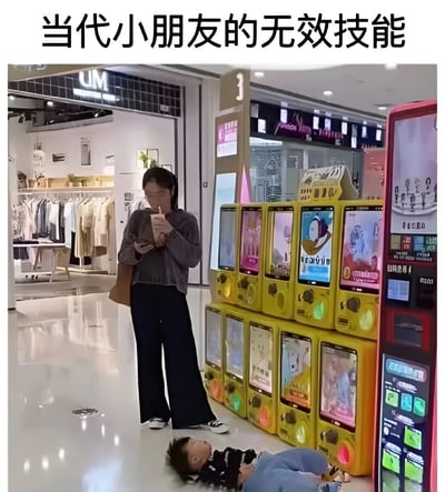 图片展示了商场内的一幕：右侧有一排黄色的抓娃娃机，机器屏幕上显示着不同的卡通图案。一名女子站在抓娃娃机旁，左手提着包，右手拿着饮料杯正在喝，同时低头专注地看着手机。她脚边的地面上，一个小孩仰面躺着，双腿弯曲，似乎在耍赖或休息。图片上方配有文字“当代小朋友的无效技能”，以幽默的方式调侃这种孩子可能通过躺地来表达诉求但未被家长关注的场景。