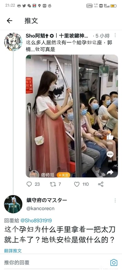 这是一张X（原推特）平台的截图，上方用户“Sho阿魈”发布了一张地铁内的照片，误将因视觉错位看起来像孕妇的女子当成真孕妇，指责车厢内无人给其让座，还使用了不当称谓；下方用户“鎮守府のマスター”则以调侃的语气指出这是视觉错觉：女子手持的地铁长扶手与身后的装饰画结合，形成了类似孕妇肚子的视觉效果，所谓的“孕妇肚子”并不存在，还戏称“孕妇拿着太刀（实际是地铁扶手）上车”，戳破了原推文的错误判断，形成了搞笑的反差效果。