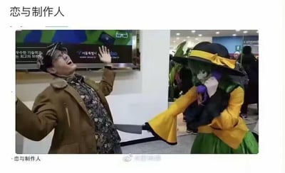 图片呈现了一场疑似《恋与制作人》主题的cosplay活动现场。左侧一名戴眼镜、身着棕色外套的男子做出夸张的仰头举手动作，表情激动，仿佛在惊呼或呼救；右侧则是一位coser，头戴黑色带黄色蝴蝶结的宽檐帽，身穿绿色与黄色拼接的服装，手持道具，两人形成有趣的互动画面。背景可见室内活动场地，有电子屏幕和其他参与者，整体氛围热闹。