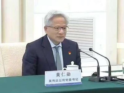 这是一张经过PS改编的恶搞图片，原图是英伟达CEO黄仁勋出席正式会议的照片，修改后在黄仁勋的西装上添加了党委徽章，桌牌文字改为“黄仁勋 英伟达公司党委书记”，通过身份错位制造反差，达到搞笑戏谑的效果，没有双关、谐音梗或暗示内容。