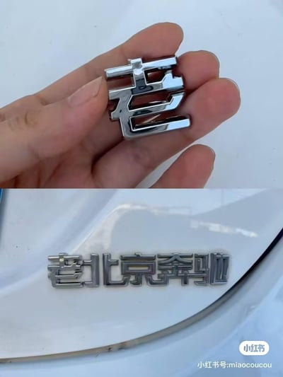 这是一张上下拼接的对比图，上图展示一只手拿着单独的镀铬“老”字车标，下图则是将这个“老”字贴在车辆尾部的“北京奔驰”车标前方，组成“老北京奔驰”的搞笑标识。通过简单的文字拼接，把原本的品牌车标改造成带有调侃意味的新内容，制造出反差感，十分有趣。