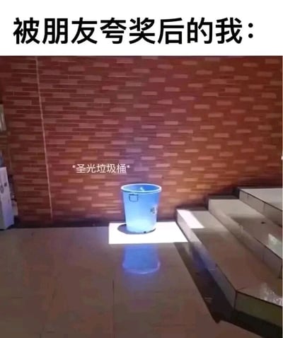 这是一张用于日常调侃的搞笑梗图，顶部配有文字“被朋友夸奖后的我：”，图中展示了一个位于室内角落的蓝色垃圾桶，恰好被一束聚光灯从上方照亮，在地面投射出蓝色的光影，营造出类似“圣光降临”的视觉效果，垃圾桶上方还标注了文字“*圣光垃圾桶*”。这张图用被“圣光”笼罩的垃圾桶来比喻人在被朋友夸奖后，自我感觉极度良好，仿佛身上被加上了光环，自信心爆棚的心理状态，通过夸张又贴合的画面，幽默地调侃了这种常见的情绪变化。