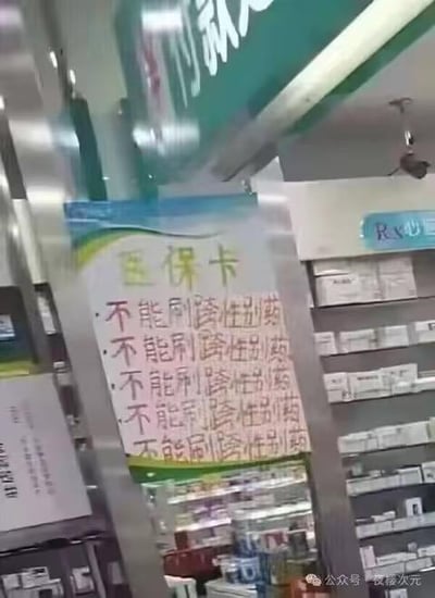 这是一张在实体药店内拍摄的实拍图，画面中的立柱上贴着一张手写的标语，标题为“医保卡”，下方连续重复书写了五次“不能刷跨性别药”，以此强调医保卡的使用限制。背景中可以看到药店的货架，上面摆放着各类药品，上方还露出了部分药店的招牌，整体场景清晰展示了药店内的相关规定，图中没有双关、谐音梗或暗示类内容。