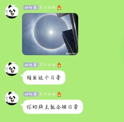 这是一张群聊截图，用户“黑与白喵”（LV14，熊猫卡通头像）首先发送了一张日晕的实拍图，图中太阳外围呈现出明显的光晕，背景是城市高楼，图片右下角带有“@航空母舰吧”的水印；随后该用户连续发送两条文字消息，先是引导“转发这个日晕”，接着利用谐音梗，说出“你的群主就会被日晕”的调侃内容，通过“日晕”的谐音制造趣味，用来调侃群主，属于群聊中活跃气氛的搞笑玩梗内容，整体氛围轻松诙谐。