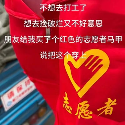 这张图的主体是一件印有黄色爱心手掌样式志愿者标志以及“志愿者”黄色字样的红色志愿者马甲实拍图，画面上方叠加了四行白色配文，内容为“不想去打工了，想去捡破烂又不好意思，朋友给我买了个红色的志愿者马甲，说把这个穿上”，用调侃的方式表达了打工人厌倦打工、又不好意思做捡破烂这类工作的自嘲心态，暗示穿上志愿者马甲捡废品就会被当做是公益活动，能消解尴尬，充满诙谐的幽默感。