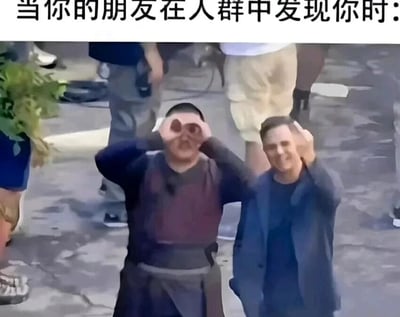 这是一张充满生活化趣味的搞笑梗图，图片上方配有文字“当你的朋友在人群中发现你时”。图中有两位男士，左侧男士双手举在眼前做出类似望远镜的手势，脸上带着兴奋的大笑；右侧男士是知名演员本尼迪克特·康伯巴奇，他单手举在眼前做出同款手势，脸上露出开心的微笑。两人夸张的动作与生动的表情，精准还原了现实里朋友在人群中找到彼此那种热情又搞怪的状态，用幽默的方式展现了朋友间相处的轻松瞬间，很容易引发网友对朋友日常互动的共鸣。