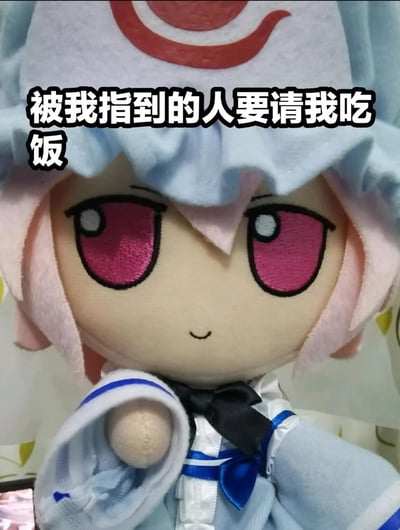这是一张用《东方Project》角色西行寺幽幽子的Fumo毛绒玩偶制作的表情包，玩偶有着粉色短发与玫红色眼睛，面带软萌的微笑，做出抬手的动作仿佛指向观看者，上方配有文字“被我指到的人要请我吃饭”，用可爱的玩偶形象来表达讨要请客的诉求，风格俏皮软萌，适合用来向朋友撒娇、讨要饭局，没有双关或谐音梗，是直白又可爱的诉求表达。