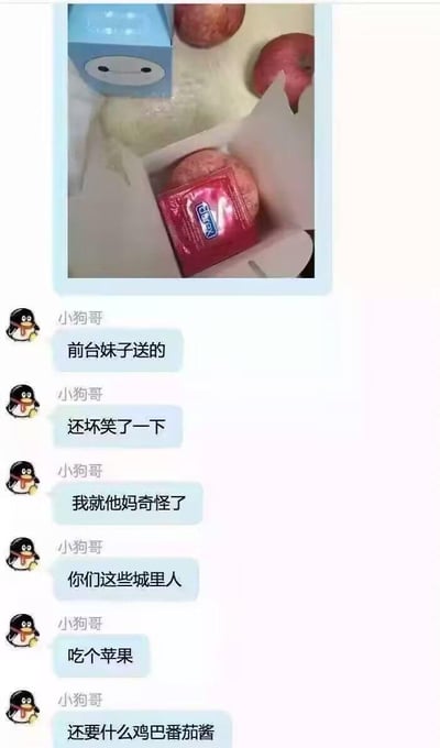 图片上方是一张实物照片：一个苹果被红色包装纸包裹，包装上的文字和设计酷似番茄酱包装袋，旁边还有其他苹果和一个带有笑脸的蓝色卡通盒子。下方是QQ聊天记录截图，用户“小狗哥”连续发送消息：“前台妹子送的”“还坏笑了一下”“我就他妈奇怪了”“你们这些城里人”“吃个苹果”“还要什么鸡巴番茄酱”。图片通过苹果包装与番茄酱包装的视觉相似性制造误会，展现了对城市生活习惯的幽默吐槽，充满生活气息和反差萌。