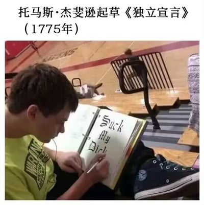 图片上方配有文字'托马斯·杰斐逊起草《独立宣言》（1775年）'，下方为一张真人场景照片：一名穿着黄色T恤的男孩坐在室内（疑似体育馆或教室）的椅子上，低头专注地在笔记本上写字，笔记本页面上清晰可见英文文字'Suck My Dick'。该梗图通过将严肃的历史事件（托马斯·杰斐逊起草《独立宣言》）与男孩书写低俗文字的场景进行强烈反差对比，营造出幽默讽刺的效果，调侃历史场景的庄重感。