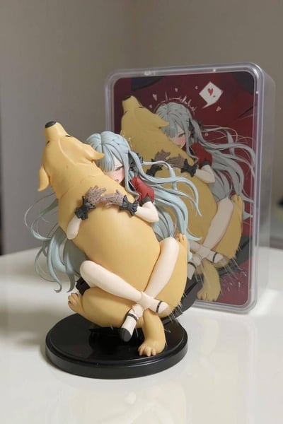 图中展示了一款还原二次元插画的银发少女抱金毛狗狗的手办，与参考的原画摆放在一起形成强烈反差。手办的制作粗糙，少女的肢体比例、头发细节都严重走形，狗狗的形态也显得僵硬怪异，和原画中细腻温馨的画风形成了类似“买家秀vs卖家秀”的搞笑对比，充满尴尬又好笑的氛围。