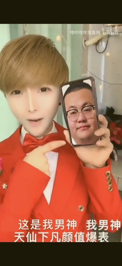 图中网红韩美娟（韩佩泉）身着红色礼服套装，妆容夸张，手持手机指向屏幕中的戴眼镜男性，下方配文重复“这是我男神”并吹捧其“天仙下凡颜值爆表”，用极具反差的形象和夸张的文案制造搞笑效果，属于鬼畜类的搞笑内容。