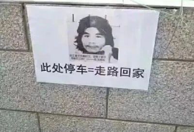 图片中是一块贴在石墙上的警告牌，牌面上方有一张周立齐（窃·格瓦拉）的黑白面部照片，下方配有文字“此处停车=走路回家”。该图通过借用“打工是不可能打工的”经典梗，幽默暗示在此处停车可能会像周立齐曾经的盗窃行为一样导致车辆丢失，最终只能走路回家，形成一种调侃式的停车警告。