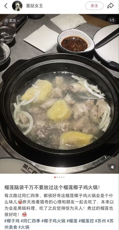 这是一张社交媒体美食分享类截图，画面上半部分是用餐场景实拍：黑色砂锅内盛放着正在沸腾的榴莲椰子鸡火锅，透明汤底中可见三块黄色的榴莲果肉、多块鸡肉以及切条的椰肉，砂锅旁摆放着盛有辣椒蘸料的小料碗、白色餐巾、空餐盘和餐具，左下角露出印有“同仁四”字样的门店专属餐盘，表明用餐地点为同仁四季门店；画面下半部分是发布者的配文，账号名为“蛋挞女王”的发布者称自己此前一直好奇该款榴莲椰子鸡火锅的口味，抱着猎奇心态尝试后并未觉得是黑暗料理，反而口味惊艳，煮过的榴莲也十分好吃，向喜欢榴莲的人群推荐该菜品，配文末尾附带了椰子鸡、同仁四季、苏州美食等相关话题标签。