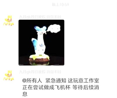 这是一张聊天群的截图，账号「九月gk」先发出宝可梦仙子伊布的手办图片，随后@所有人发布紧急通知，表示工作室正在尝试将该手办造型改造为飞机杯，等待后续消息。内容将可爱的宝可梦手办与成人用品结合，通过强烈的反差感制造玩梗搞笑的效果。