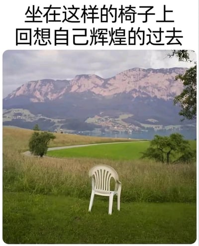 图片上方有黑色文字'坐在这样的椅子上回想自己辉煌的过去'，下方是一张自然风景照：绿色草地上放置着一把白色塑料椅，背景为连绵的山脉和远处的湖泊，天空中云层较厚。整体画面通过普通的塑料椅与壮丽的自然景观形成对比，营造出一种在平凡场景中回忆过往辉煌的怀旧氛围，带有一丝幽默与感慨的情绪。