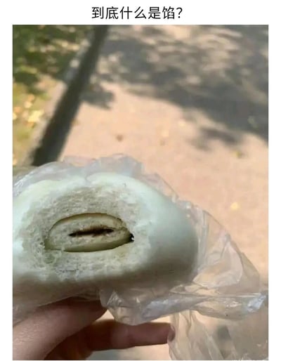 这张图展示了一只被掰开、装在透明塑料袋里的夹心面点，外形类似夹馅馒头或包子，但其内部的馅料少得夸张，仅在中心位置有一条极细的深色夹心，几乎被厚实的外层面皮完全包裹。图片上方配文“到底什么是馅？”，以调侃的语气吐槽这款食品馅料严重不足，和消费者对夹馅食品的预期差距极大，充满了搞笑与吐槽的意味，容易引发有类似踩雷经历的网友共鸣。