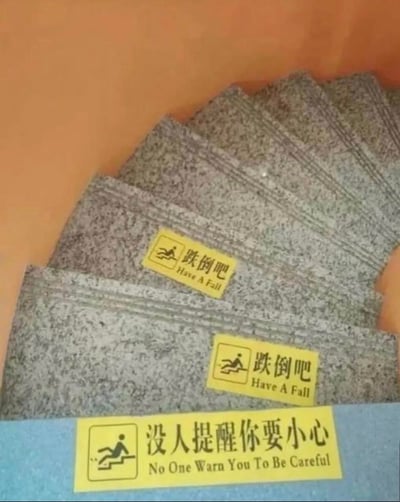 这是一张拍摄楼梯台阶的照片，台阶上贴有三张黄色警示贴纸：前两级台阶的贴纸印有摔倒小人图标，配文“跌倒吧 Have A Fall”，最后一级台阶的贴纸同样有摔倒小人图标，配文“没人提醒你要小心 No One Warn You To Be Careful”。该内容采用反套路的玩梗方式，先用反向的搞笑文案制造反差，最后才传递出真正的安全提醒，以幽默的方式警示人们上下楼梯时注意安全。