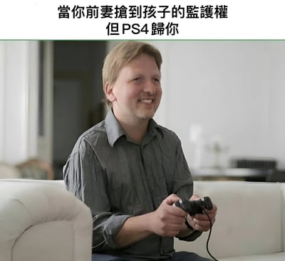 图片展示了一个中年男子坐在沙发上，双手握着PS4游戏手柄，脸上带着满足的微笑。图片上方配有文字：'當你前妻搶到孩子的監護權 但PS4歸你'，通过对比失去孩子监护权和获得PS4的反差，制造出黑色幽默的效果。