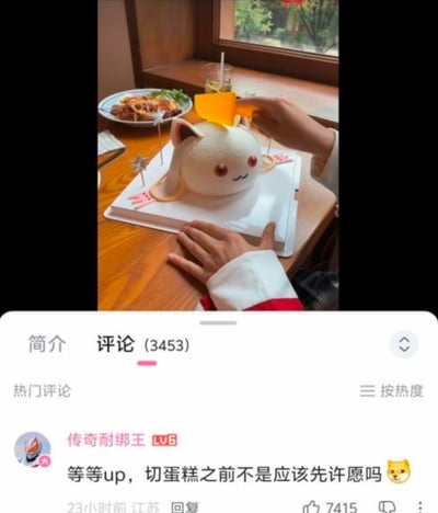 这是一张来自哔哩哔哩的视频截图，画面中有人正准备切开还原《魔法少女小圆》角色丘比的造型蛋糕，下方的热门评论玩梗留言：“等等up，切蛋糕之前不是应该先许愿吗😺”。这个评论紧扣丘比的角色设定——它会以实现愿望为条件和魔法少女签订契约，但背后却是残酷的命运陷阱，用日常的切蛋糕许愿场景玩动漫梗，充满了反差感和趣味性。