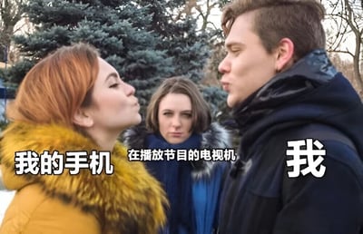 图片展示了户外场景下的三人互动：左侧红发女性穿着黄色带毛领外套，身体向右倾斜作亲吻状，身上标注“我的手机”；右侧男性穿着深色外套，闭眼面向左侧女性，身上标注“我”；中间女性穿着蓝色外套，面无表情地站在两人中间，标注“在播放节目的电视机”。背景有松树等树木，整体通过人物关系幽默表现了手机和电视对人注意力的争夺。