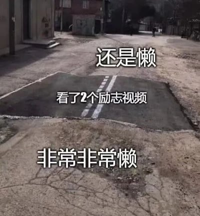 图片展示了一条路面粗糙、中间有明显坑洼的街道场景，上方叠加了三行白色文字：顶部为“还是懒”，中间是“看了2个励志视频”，底部为“非常非常懒”。通过路面的坑洼与文字内容形成幽默对比，调侃了人们在观看励志内容后依然无法克服懒惰、不愿行动的矛盾心理。