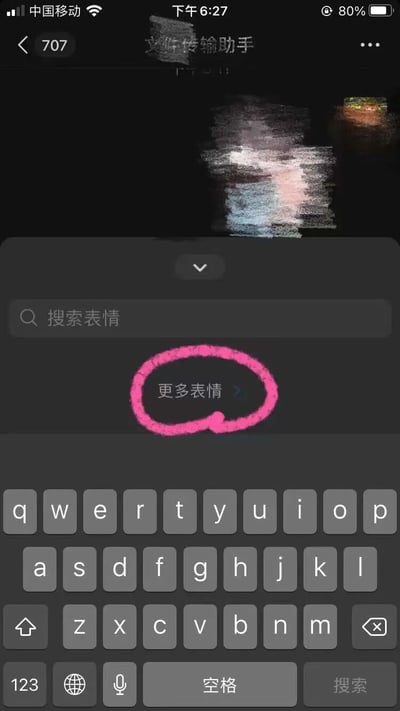 这是一张手机聊天界面的截图，显示与'文件传输助手'的对话窗口，顶部可见聊天对象名称及数字'707'。界面中部有搜索表情的搜索框，下方'更多表情'按钮被粉色圆圈醒目标记，底部为手机键盘。整体色调偏暗，粉色圆圈突出了'更多表情'的位置，可能用于指引用户查找更多表情的入口。
