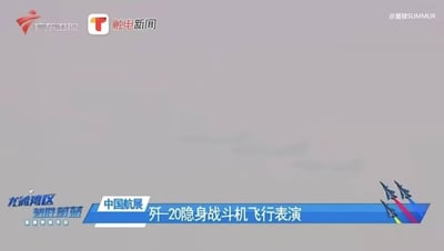 这是广东卫视与触电新闻联合播出的新闻画面截图，背景为浅灰色天空，顶部左侧显示两家媒体的logo，右侧有水印@夏穆SUMMUR。画面底部有蓝色信息条，内容为“中国航展 歼-20隐身战斗机飞行表演”及“龙湖区 驾胜蔚蓝”，整体呈现正式的新闻报道风格，用于传递中国航展相关动态。