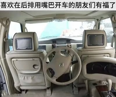 整张图是车辆内部实拍改图，车辆主驾驶位配置正常，在前排两个座椅的后方、后排空间的中间位置，额外加装了一个和驾驶位同款的日产汽车方向盘，图顶部配文“喜欢在后排用嘴巴开车的朋友们有福了”，用来调侃现实中乘车时总坐在后排对司机的驾驶操作指手画脚、仿佛自己在开车的人，玩了“用嘴开车”的引申梗，笑点在于给这类喜欢指挥他人驾驶的人真的配备一个方向盘，满足他们“开车”的需求。