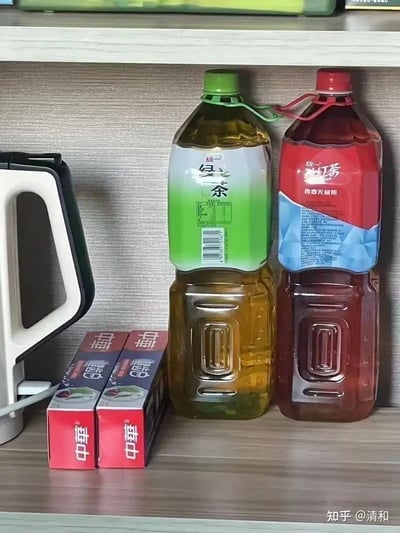 这张图乍看是两瓶茶饮料（绿茶和红茶）整齐摆放，实际仔细观察会发现瓶里的液体分别是油和酱油，并非真正的饮料。这种错位混搭的摆放方式很容易让人误以为饮料和调味品混淆，属于典型的家庭迷惑行为大赏。图中并没有明显的双关、谐音梗或暗示，但整体场景充满了幽默的生活气息，让人联想到“生活中的小误会”。