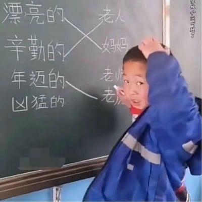 这是一张教室实拍图，黑板上是语文形容词与名词的连线作业：左侧为「漂亮的、辛勤的、年迈的、凶猛的」，右侧为「老人、妈妈、老师、老虎」。但图中的小学生做出了迷惑连线：漂亮的-老人，辛勤的-妈妈，年迈的-老师，仅「凶猛的-老虎」正确。画面中的小学生穿着蓝色校服，双手抓头，表情惊慌夸张，身体侧开，看起来害怕被老师批评，错位的搭配加上孩子的反应让画面充满搞笑感。