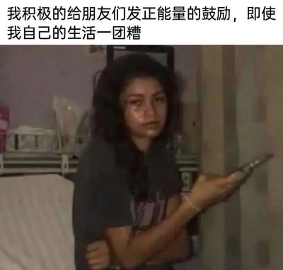 这是一张文字加注的真人静态图，画面中的女生头发凌乱，满脸泪痕，双臂环抱自己，看起来正处于情绪崩溃的状态，却依然拿着手机，结合上方的配文“我积极的给朋友们发正能量的鼓励，即使我自己的生活一团糟”，精准刻画了当代很多人的一种状态——在自己生活不顺、情绪低落时，依然会优先顾及朋友的情绪，为朋友传递温暖和鼓励，独自消化自身的负面情绪，这种强烈的反差引发了很多人的情绪共鸣，是很能戳中人心的自嘲类梗图。