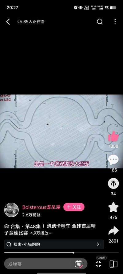 这是抖音平台的一条创意恶搞视频截图，作者将微观视角下的精子运动，改编成模仿《跑跑卡丁车》的竞速比赛，玩了谐音梗——“跑跑卡精车”对应“跑跑卡丁车”，“精车”谐音“精子”。画面中是类似竞速赛道的微观场景，几个黑点模拟精子在赛道中“竞速”，画面配文“这是一个微观游泳大师班”，用幽默戏谑的方式将严肃的生理现象转化为趣味竞速游戏内容，风格恶搞搞笑，适合在社交平台作为整活内容传播。