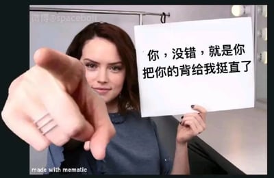 图片中一位女性右手伸出食指指向镜头方向，左手拿着一张写有‘你，没错，就是你 把你的背给我挺直了’的白色纸牌。背景为室内房间，光线明亮。整体风格带有直接的提醒和督促意味，常用于在社交媒体上提醒他人注意坐姿或站姿，纠正不良体态。