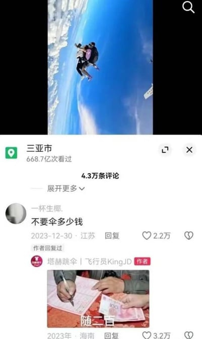 图片为社交媒体截图，上方是三亚跳伞场景，一名跳伞者在空中，背景为蓝天白云。下方显示地点“三亚市”及668.7亿次看过、4.3万条评论。评论区中用户“一杯生椰.”留言“不要伞多少钱”，作者“塔赫跳伞｜飞行员KingJD”回复一张图片，内容为手写纸张和百元人民币，配文“随二百”，整体呈现幽默的评论互动场景。