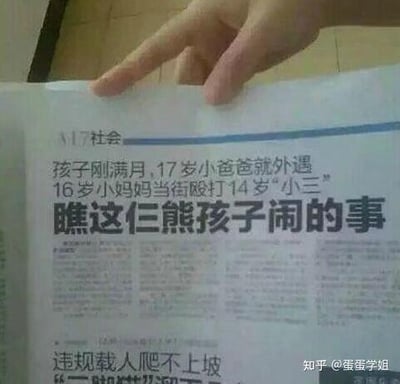 这是一张翻拍的报纸社会新闻版面，画面上方有一只手的手指指向报纸标题区域。报纸的核心新闻标题为「孩子刚满月,17岁小爸爸就外遇 16岁小妈妈当街殴打14岁"小三" 瞧这仨熊孩子闹的事」，下方还露出另一则新闻的开头「违规载人爬不上坡」。这则新闻的所有当事人均为未成年人，17岁就成为父亲还婚内出轨，16岁的母亲当街打人，14岁的女孩成为外遇对象，这种低龄化的家庭伦理事件完全超出常规认知，内容荒诞离谱，很容易引发网友对未成年人过早涉足亲密关系、缺乏责任意识的讨论。