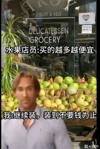 这是一张经过二次创作的搞笑梗图，背景是一家标注有英文“FRUIT & VEG”“DELICATESSEN GROCERY”的线下水果店，店外摆放着满满一堆各类新鲜水果。创作者将一个男性人物的图像合成到水果堆前的位置，并配上两段对话文字：水果店员称“买的越多越便宜”，而“我”则顺着这个逻辑抬杠，回应“继续装，装到不要钱为止”，用夸张的方式放大了“量大优惠”的营销话术，制造出荒诞又搞笑的效果，精准戳中人们对促销话术的调侃心理。
