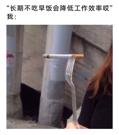 这是一张图文结合的搞笑网络梗图，上方配有文字“长期不吃早饭会降低工作效率哎”以及代表回应的“我：”，下方的实拍图中，仅露出部分身体的真人手持一根被掰弯的塑料叉子，叉子的叉齿部分架着一根已经点燃、带有燃烧灰烬的香烟。整幅图通过这种荒诞、摆烂的行为，来回应关于“不吃早饭会降低工作效率”的健康提醒，传递出当代年轻人对这类职场相关健康要求的无所谓、摆烂的心态，用自嘲和戏谑的方式调侃职场生活与健康规范之间的矛盾，充满了接地气的搞笑氛围。
