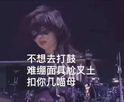 图中是一位戴着黑色面具的女性鼓手，坐在架子鼓前，表情透露出明显的无奈与嫌弃。图上配文为“不想去打鼓 难绷面具尬又土 扣你几喵母”，其中“扣你几喵母”是谐音梗，谐音“扣你几毛钱”，用可爱的“喵母”替代“毛钱”，以搞笑的方式放大了人物对被迫打鼓、佩戴土气面具的抗拒情绪，精准戳中人们被迫做自己反感、觉得尴尬的事时的心情，整体氛围诙谐有趣。