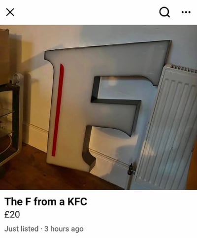 这是一张二手交易平台的截图，画面主体是一个从肯德基（KFC）招牌上拆下来的立体字母“F”，它被放置在室内的墙角处，旁边有玻璃柜和暖气片。下方的交易信息标注了“The F from a KFC”，标价20英镑，还显示“Just listed · 3 hours ago”（刚刚上架·3小时前）。这个内容的趣味点在于将品牌招牌的单个字母作为商品出售，行为十分无厘头，让人觉得搞笑。