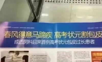 这是一张翻拍的男科医院宣传物料照片，画面主体为蓝色背景的宣传标语，文案将古诗名句“春风得意马蹄疾”强行拼接上“高考状元割包皮”的违和内容，下方补充标注“成西男科迎来首例高考状元包皮过长患者”，属于医疗机构为了蹭高考热点制作的低俗无逻辑营销内容，画面背景能看到室内的光亮瓷砖地面，宣传页下方还有模糊的人物配图和文字内容。