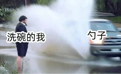 图片左侧一名穿着西装的男子背对镜头站立，右侧一辆汽车正朝着他的方向喷射出大量水花。男子身上被标注“洗碗的我”，汽车喷射的水花处被标注“勺子”，通过夸张的洗车喷水场景，幽默比喻洗碗时清洗勺子可能出现的过度用力、水花四溅的搞笑情景，展现日常生活中的小趣事。