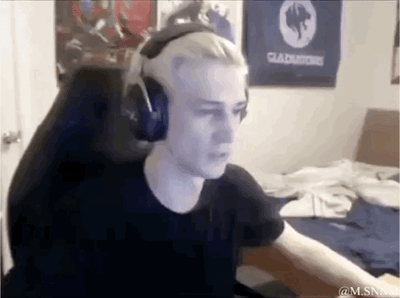 这是一段截取自主播xQc直播画面的GIF动态图，画面中xQc戴着耳机专注于直播，他身后的物体突然移动，形成了他的头发瞬间变得异常茂密又快速恢复的视觉错觉，效果十分滑稽搞笑，常被用来玩“头发茂密”相关的反差梗，调侃脱发或者突发的状态变化。