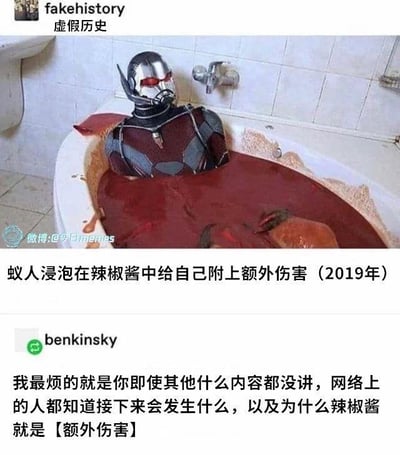 图片中，漫威超级英雄蚁人身穿战衣，正浸泡在一个装满红色辣椒酱的浴缸里。浴缸周围溅满了辣椒酱，背景是白色瓷砖的浴室。图片上方有文字“fakehistory 虚假历史”，中间配有文字“蚁人浸泡在辣椒酱中给自己附上额外伤害（2019年）”，下方是用户“benkinsky”的评论：“我最烦的就是你即使其他什么内容都没讲，网络上的人都知道接下来会发生什么，以及为什么辣椒酱就是【额外伤害】”。这张梗图通过将蚁人置于荒诞的辣椒酱浴缸场景中，结合游戏术语“额外伤害”制造幽默效果，暗示辣椒酱带来的刺痛感如同游戏中的额外伤害效果。