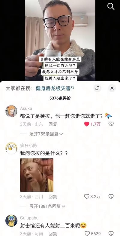 图片上半部分为一名戴眼镜男子手持杯子，配文“真的有人能在健身房里硬拉一两百斤吗？我怎么才拉不到半斤就被人赶出来了？”。下半部分是社交平台的评论区截图，顶部显示“大家都在搜：健身房龙级灾害”及5376条评论。热门评论包括Asuka的“都说了是硬拉，他一赶你走你就走了？”（1.7万赞）、疯狂小陈的“我问你拉的是什么？？”（附表情包，3.2万赞）以及Gulupabu的“射击馆还有人能射二百米呢😂”（5629赞），整体充满搞笑调侃氛围。