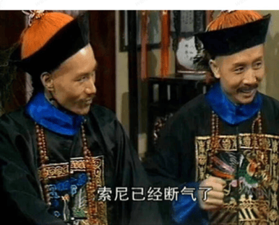 这是一张出自电视剧《康熙王朝》的剧照截图，画面中呈现两位身着清代官员服饰的人物，左侧官员侧身看向右侧，神情平静；右侧官员面带笑容，手部抬起，似乎在传递消息，画面下方的字幕显示‘索尼已经断气了’，对应剧中索尼去世的相关剧情场景，整体构图清晰，还原了剧中的历史场景氛围。